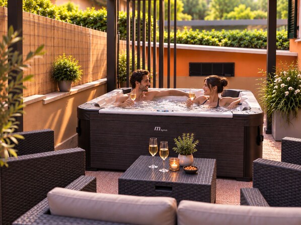 A spa area with a hot tub, wicker furniture, and a table with glasses and candles. - Nice apartment in Rome (Roma)
