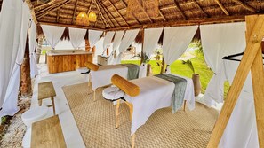 A thatched-roof outdoor spa area with massage tables, white drapes, and a wooden bench. - Azulea Bacalar Hotel & Spa - Lagoon Front (Bacalar)