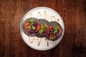 A plate with a food item on a wooden table. - Azulea Bacalar Hotel & Spa - Lagoon Front (Bacalar)