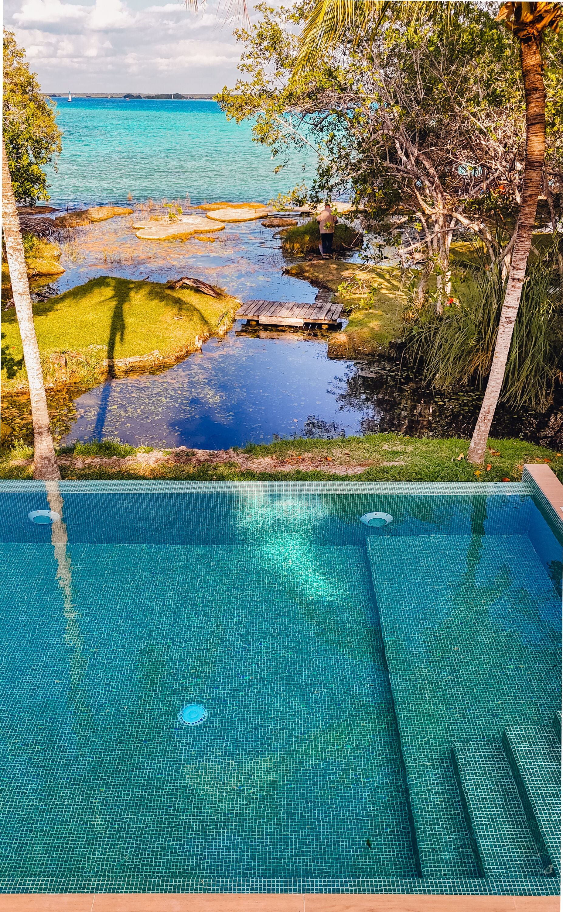 Una piscina al aire libre, sombrillas, tumbonas
