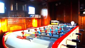 A foosball table in a room with wooden walls and a window. - Exceptionnel. Bateau Logement (Ailly-sur-Somme)