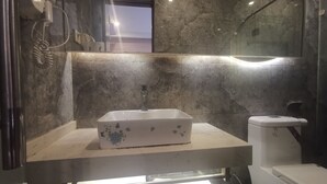 A bathroom with a white sink, a toilet, and a shower area. - Beijing Huiqing Garden Bussiness Hotel (Beijing)