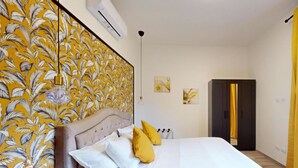 A bedroom with a bed, a wardrobe, and a window with curtains. - Charming terrace apartment (Firenze)