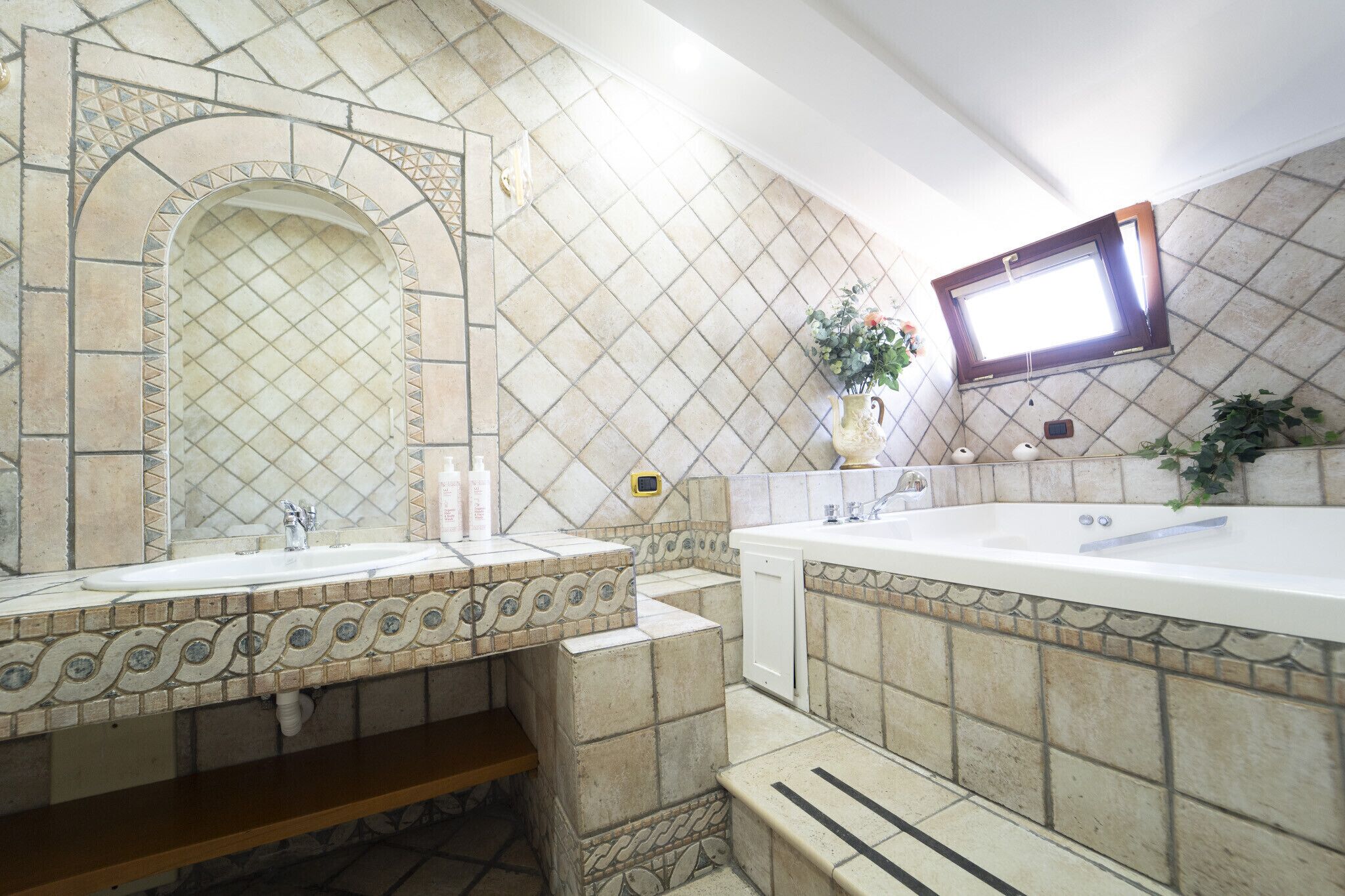A bathroom with two sinks, a large mirror, and a bathtub.