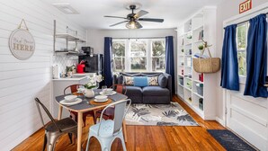 A cozy living area with a dining table, chairs, a sofa, and a ceiling fan. - Saragossa Sunshine Unit B (St. Augustine)