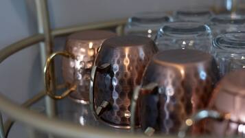 Gros plan de chopes en cuivre munies d’anses, posées sur un plateau en métal.