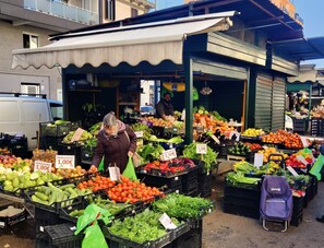 Un puesto de mercado con diversas frutas y verduras a la vista.