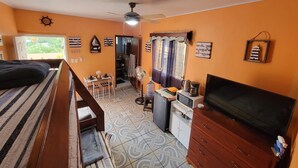 A compact room with a bed, a small kitchenette, a TV, and a fan. - Cozy 1-bedroom guest house with WiFi, AC in fabulous Marcala (La Paz)