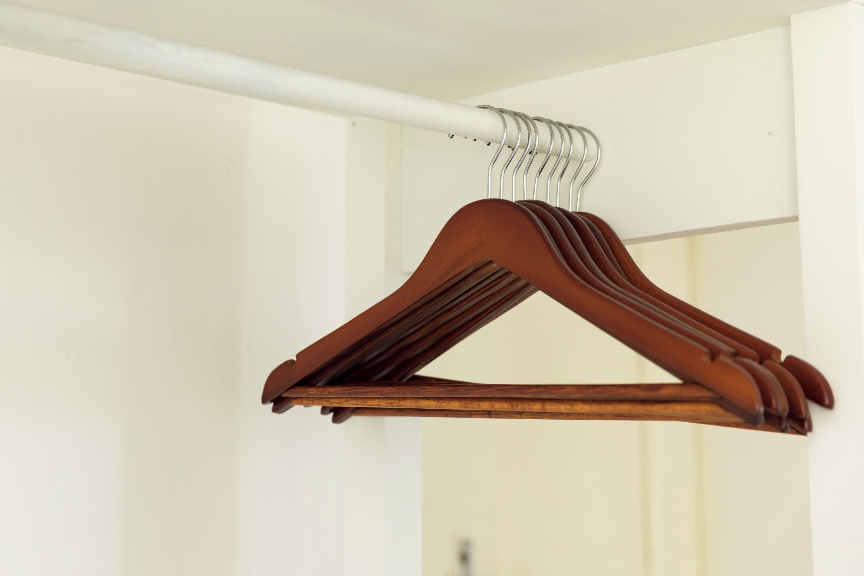 Un cintre en bois sur un mur blanc.