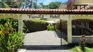 A Family Hotel entrance with a tiled roof, a satellite dish, and a sign. - Family Hotel (Cahuita)