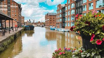 A canal with boats, buildings, and a flower pot.