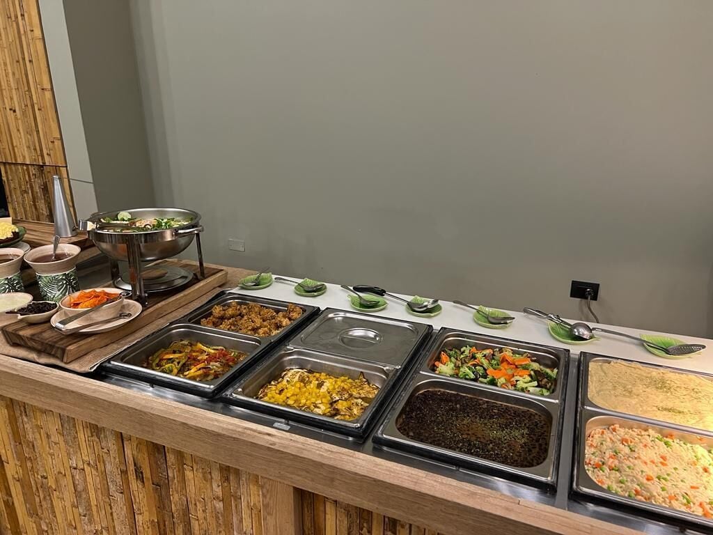 Un bufé con diversas opciones de comida, incluyendo ensaladas, carnes y cazuelas.