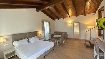 A bedroom with a bed, bedside tables, a desk, and a chair.