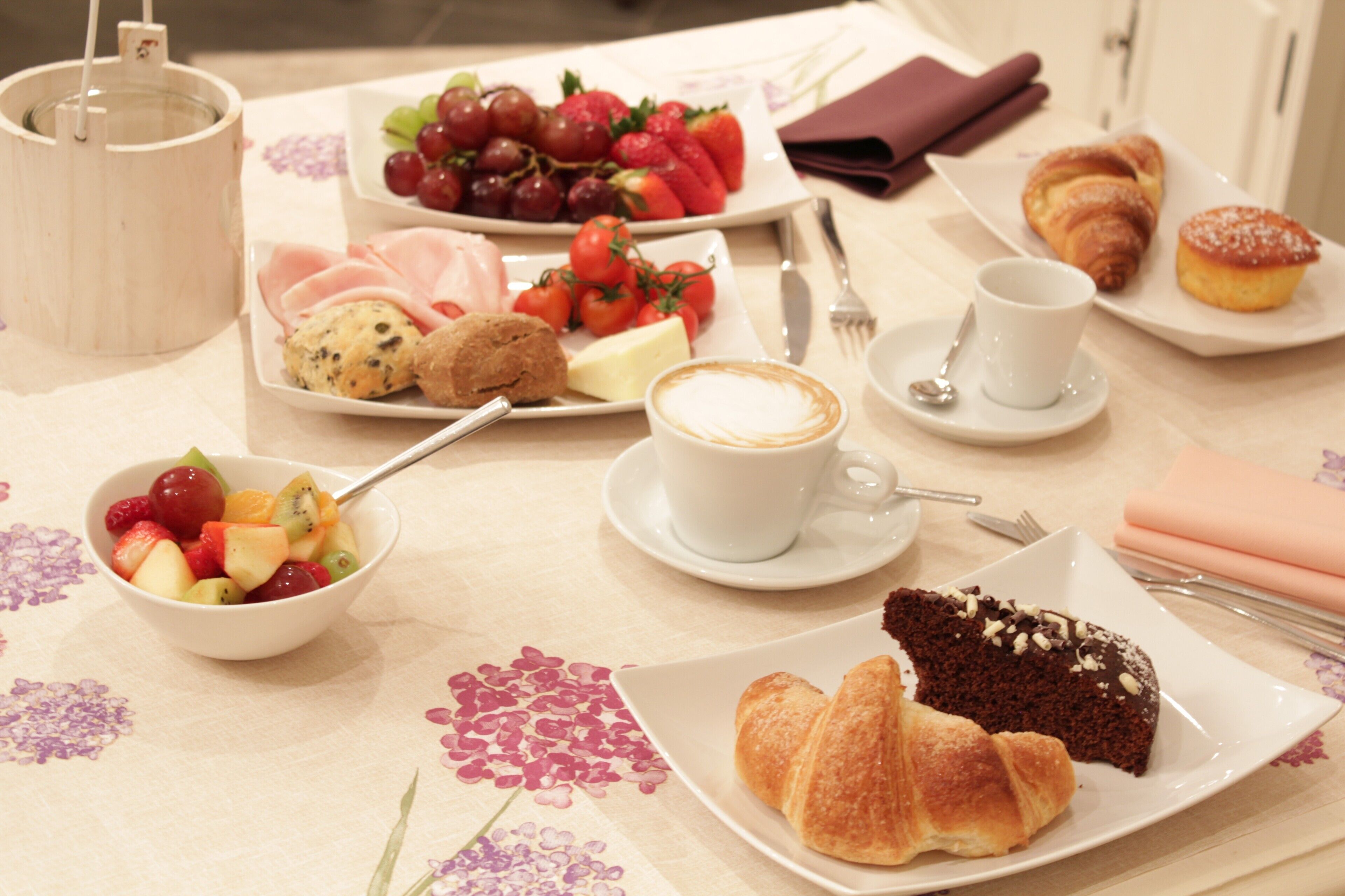 Une table dressée pour le petit-déjeuner, avec divers aliments et une tasse de café.