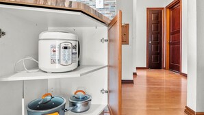 A kitchen with a built-in stove, a microwave, and two pots on the countertop.