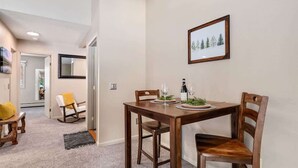 Ein Essbereich mit Holztisch, Stühlen und einem gerahmten Bild an der Wand.