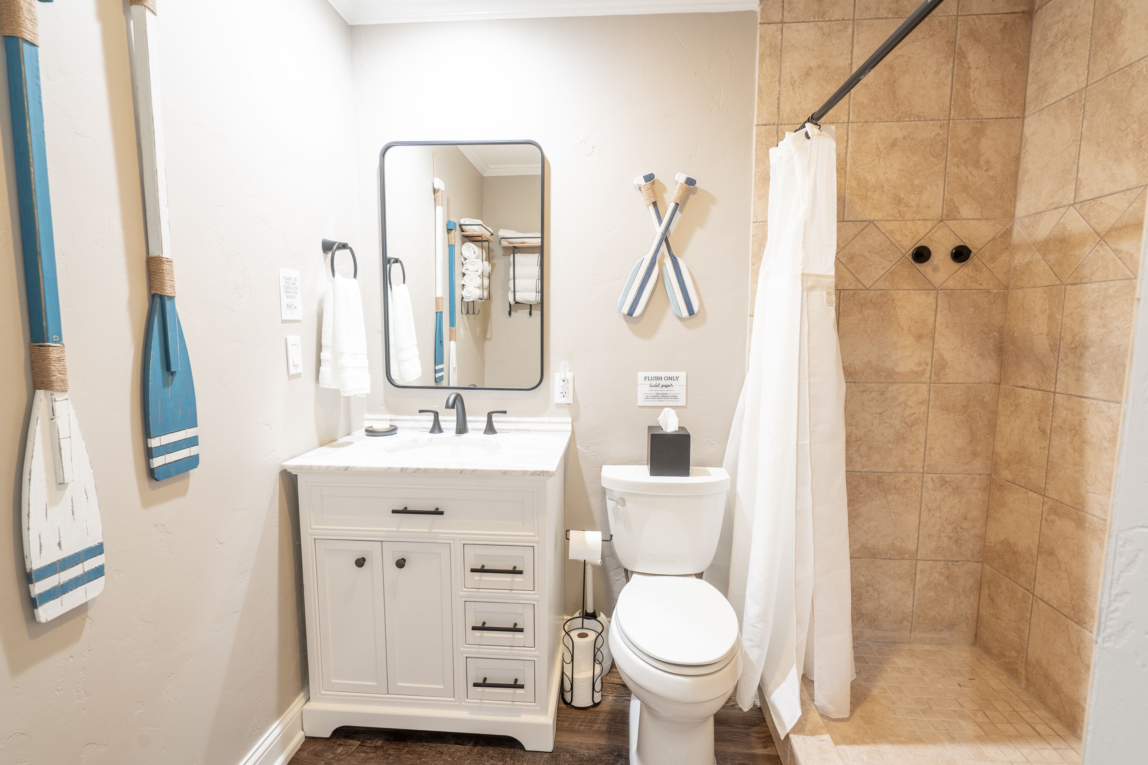 Une salle de bain avec un meuble-lavabo blanc, des toilettes et un espace douche.