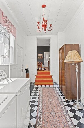 A hallway with a checkered floor, a patterned rug, a red chandelier, and a lamp. - Historic Ward Home - Experience history in the horse country! 5br 5.5bth (Lexington)
