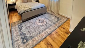 A bedroom with a bed, nightstands, a rug, a window with curtains, and a ceiling light. - Elegant Brady St Home with Excellent Walkability (Milwaukee)