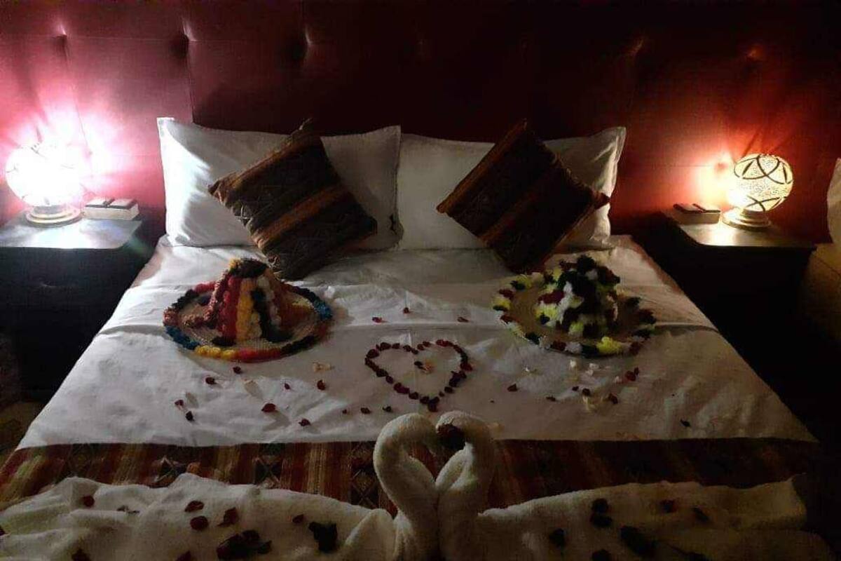 Un lit avec deux gâteaux et des décorations en forme de cœur sur un drap blanc.