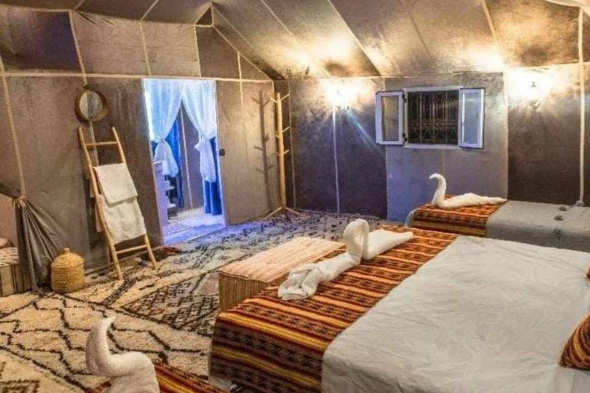 Une pièce aménagée comme une tente, avec un lit, une échelle, un miroir et une fenêtre.