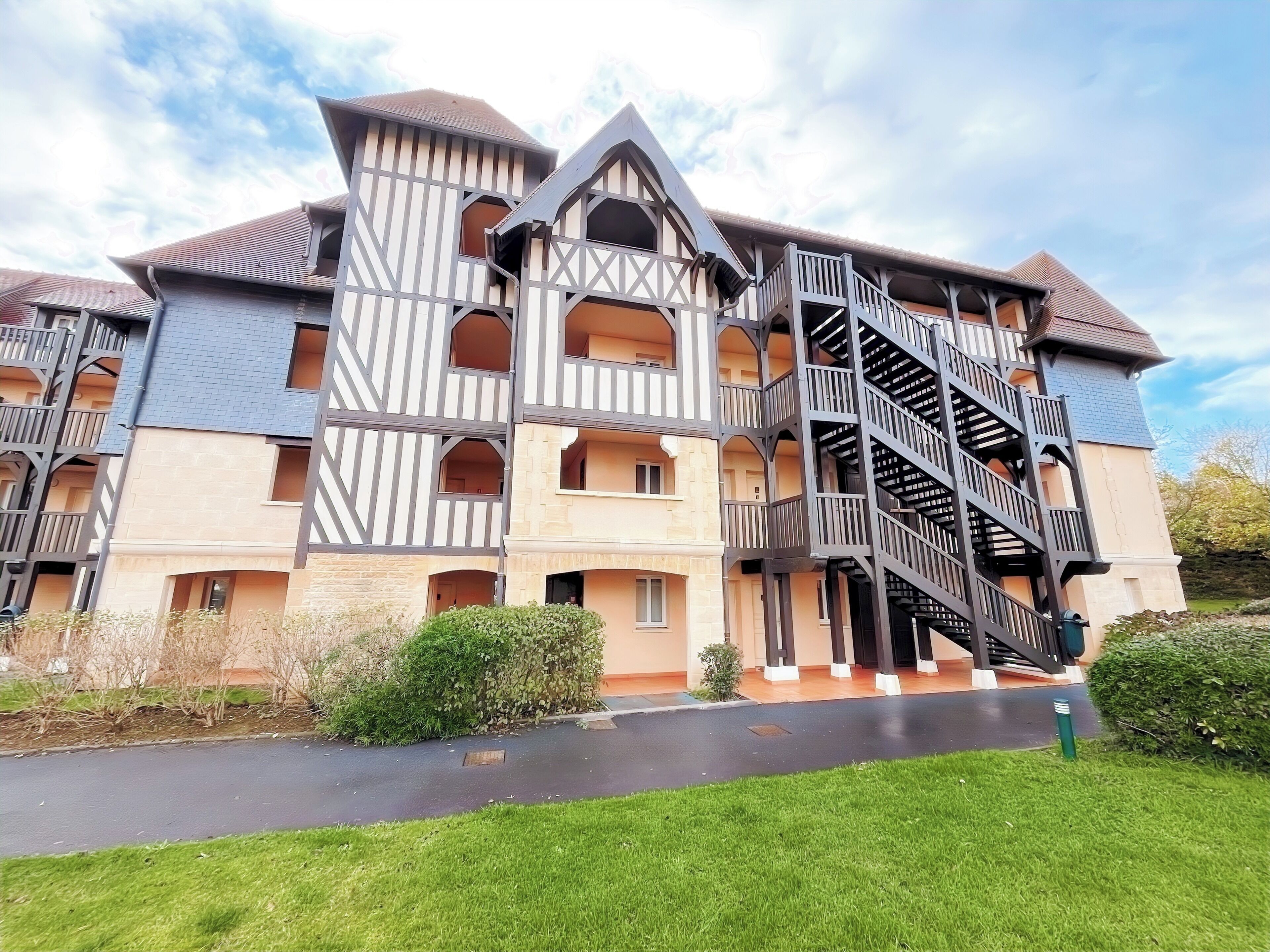 A multi-story building with a distinctive architectural design, featuring a central staircase and multiple balconies.