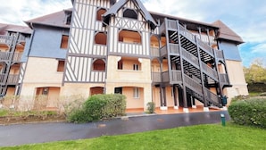Un immeuble à plusieurs étages doté d’une architecture remarquable, avec un escalier central et de nombreux balcons.