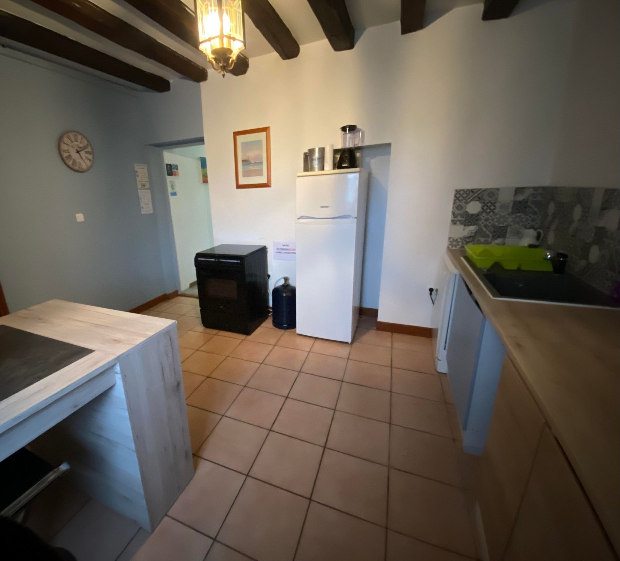 A kitchen with a wooden countertop, a refrigerator, a stove, and a sink.