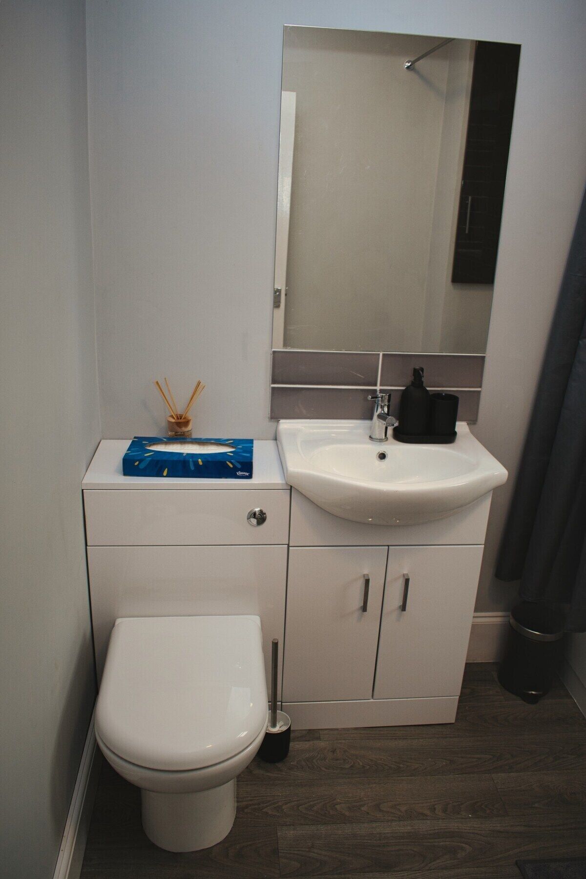 A bathroom with a white toilet, a white sink, and a mirror above the sink.