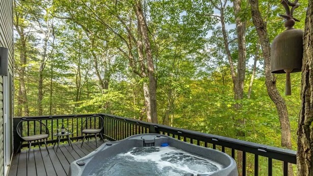 A hot tub on a wooden deck surrounded by trees. - The Nest · Hot Tub, Forest Views & Soaking Tub (Berkeley Springs)