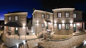 Un bâtiment en pierre doté de nombreuses fenêtres et d’un balcon.