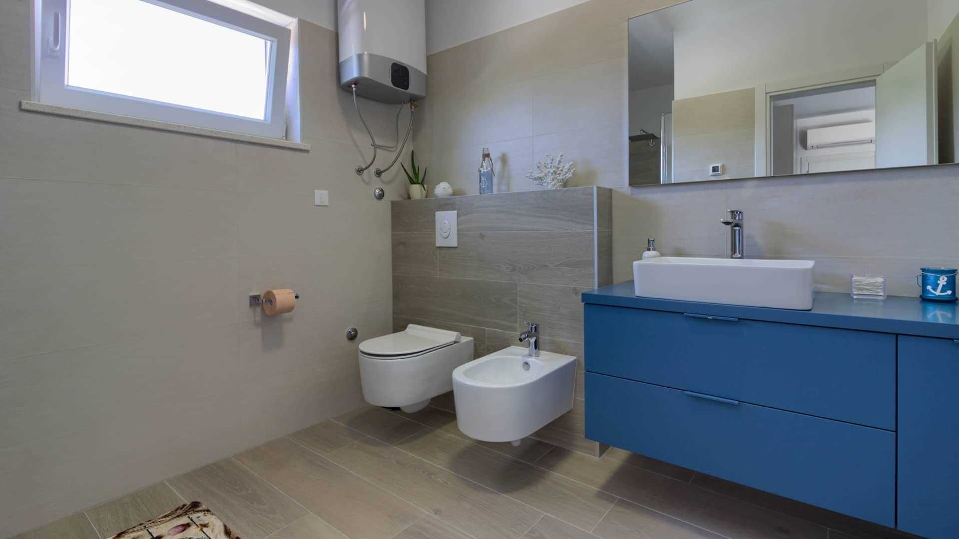 Une salle de bain moderne équipée d’un bidet, d’un lavabo et d’un miroir.