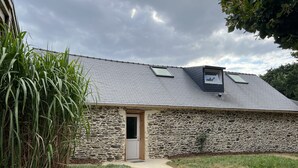 A stone building with a sloped roof, a small door, and a pathway leading to it. - Gîte 3 Chambres, Très Lumineux (Crédin)