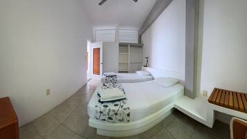 A bedroom with a curved bed, a desk, and a chair.