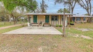 A small, single-story building with a porch and a concrete patio area. - Horse Farm Cottage Near WEC + Rainbow Springs (Morriston)