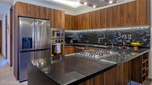 A modern kitchen with a stainless steel refrigerator, built-in oven, microwave, and gas stove. - Increible y Moderno Departamento con Mucho Espacio, Ideal Para Quien sea (Bucerías)