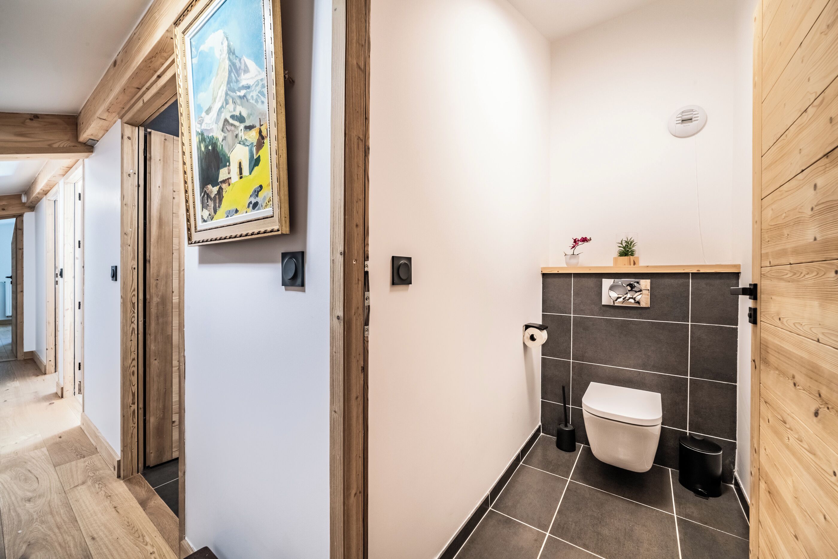 A modern bathroom with a toilet, sink, and shower area.
