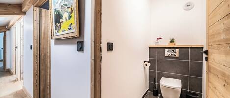 A modern bathroom with a toilet, sink, and shower area.