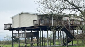 A two-story house with a deck and a staircase.