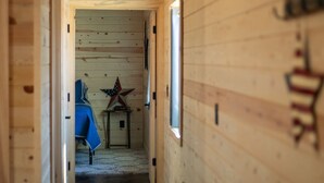 Ein holzgetäfelter Flur mit einem Bett und einer Stern-Dekoration im Hintergrund.