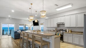 A spacious kitchen with a large island, white cabinetry, and a view of the ocean. - Beachfront Private Home 5 BR 4.5 Bath Pet Friendly (Port Saint Joe)