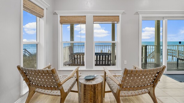 A room with two wicker chairs facing a large window with a view of a balcony and the ocean. - Beachfront Private Home 5 BR 4.5 Bath Pet Friendly (Port Saint Joe)