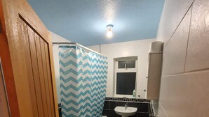 A bathroom with a shower, sink, and a mirror. - Detached 4-bed House in Leeds (Leeds)