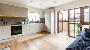 A modern kitchen with a built-in oven, a coffee machine, and a window overlooking the city. - City View Spacious 2 Bedroom Penthouse (London)