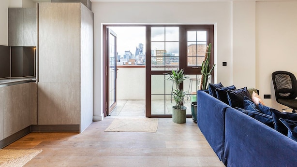 A modern apartment with a kitchen, a living area with a sofa and chairs, and a balcony with a city view. - City View Spacious 2 Bedroom Penthouse (London)