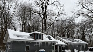 A row of two-story houses covered in snow, surrounded by leafless trees. - Delightful cottage with huge yard on heavily wooded one acre lot in Union Pier. (Union Pier)