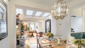 Et spiseområde med højt til loftet, ovenlys og en stor lysekrone i midten.