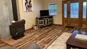 Ein Wohnzimmer mit Kamin, Fernseher und einer Tür mit satinierten Glasfeldern.