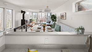 Une cuisine moderne dotée d’un îlot central, d’un coin repas avec un canapé et d’une vue sur l’extérieur.