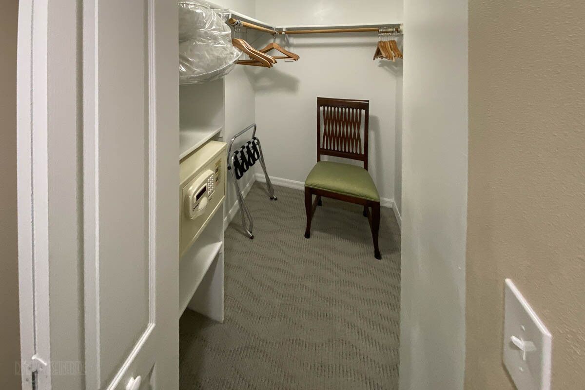 A small, narrow room with a wooden chair and a white dresser.
